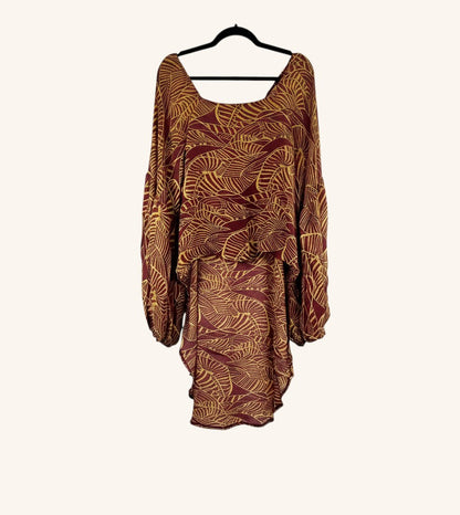 She Lives Beauty Desert Rain silk top in maroon and gold with a leaf print, oversized ruffle sleeves, and hi-low hem.