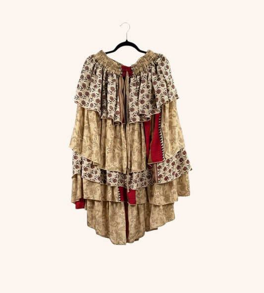 She Lives Beauty Ruffle Muse hi-lo skirt in vintage beige Rasgulla silk with floral patterns and cascading ruffles.