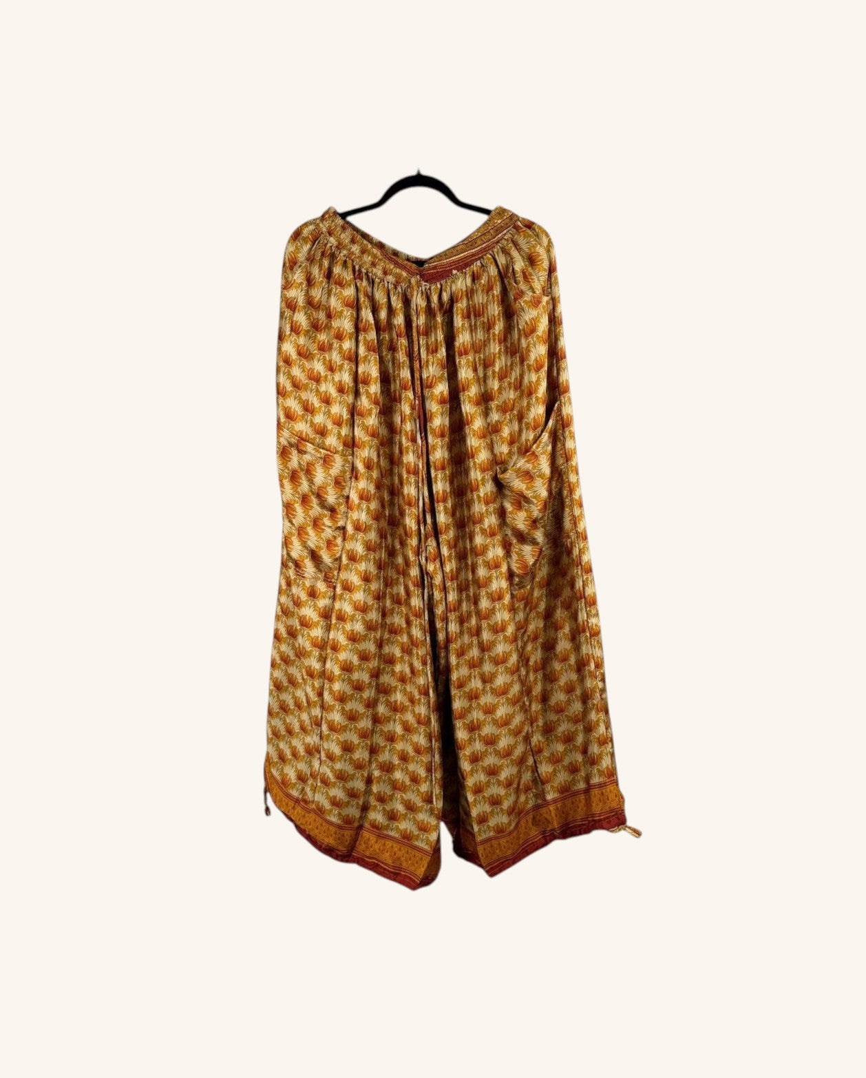 She Lives Beauty vintage rasgulla silk wide leg jogger pants in a warm yellow and orange floral print pattern.