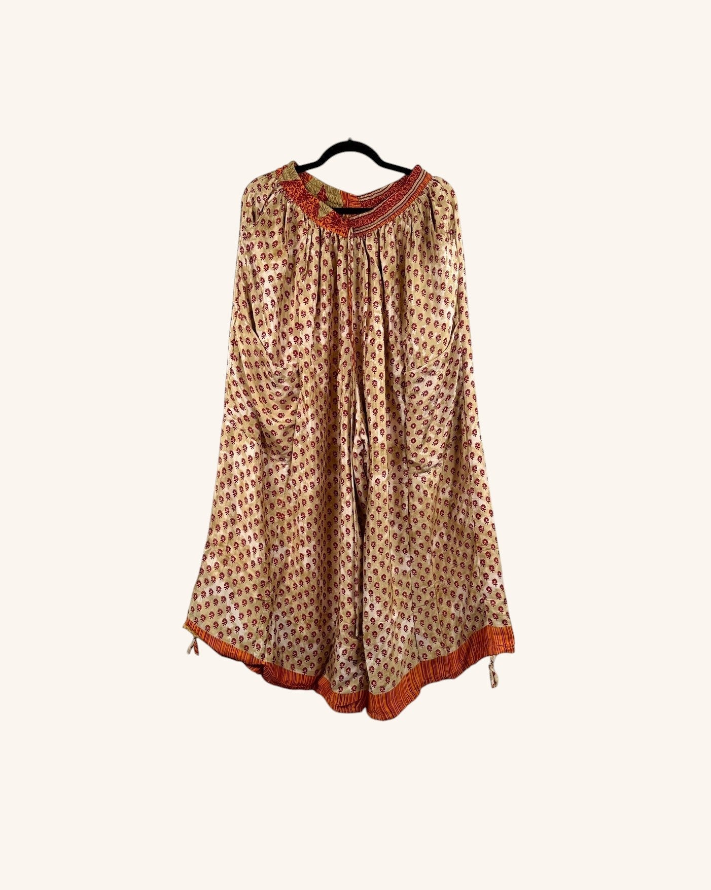 She Lives Beauty vintage silk wide-leg jogger pants in a cream and red floral print with an orange waistband.