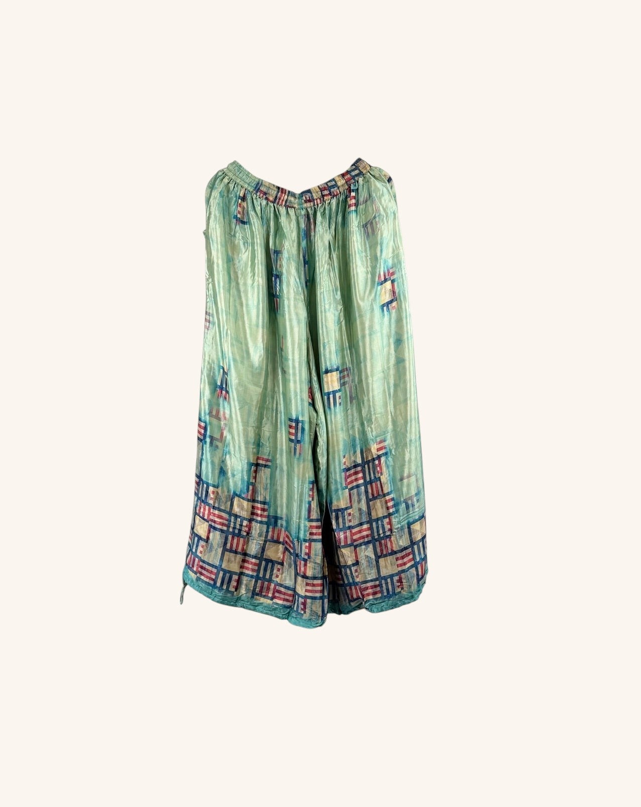 She Lives Beauty vintage rasgulla silk wide leg pants in a light green patchwork pattern with red and blue accents.